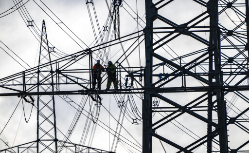 Arbeiten an einer 380-kV Höchstspannungsfreileitung, Neubau, entlang der Autobahn A57, bei Meerbusch, Arbeiter auf den Auslegern des Hochspannungsmasts, NRW, Deutschland,