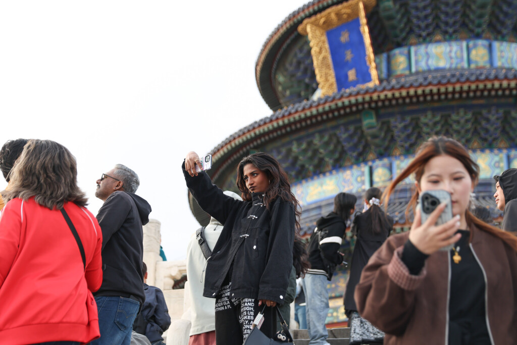 oreign tourists pose for a photo at the Tiantan (Temple of Heaven) Park during the Qingming Festival holiday in Beijing.